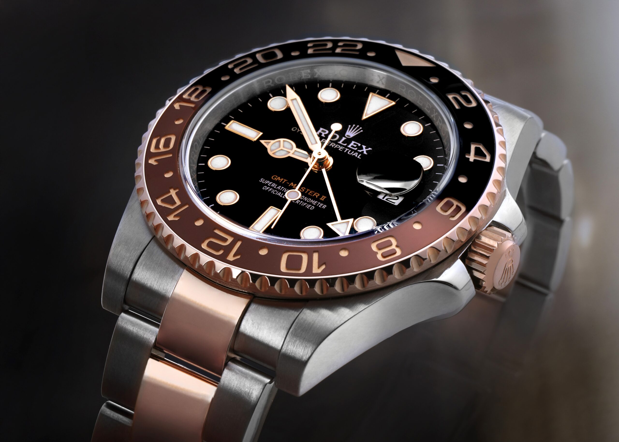 Close-up of a two-tone Rolex GMT-Master II "Root Beer" watch highlighting the pristine brushed steel and polished Everose gold finishing.
