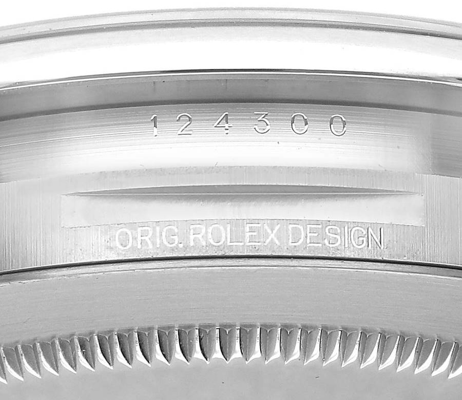 Close-up of the metal case between the lugs of a Rolex watch showing the clearly engraved model number 124300 and the words ORIG ROLEX DESIGN.