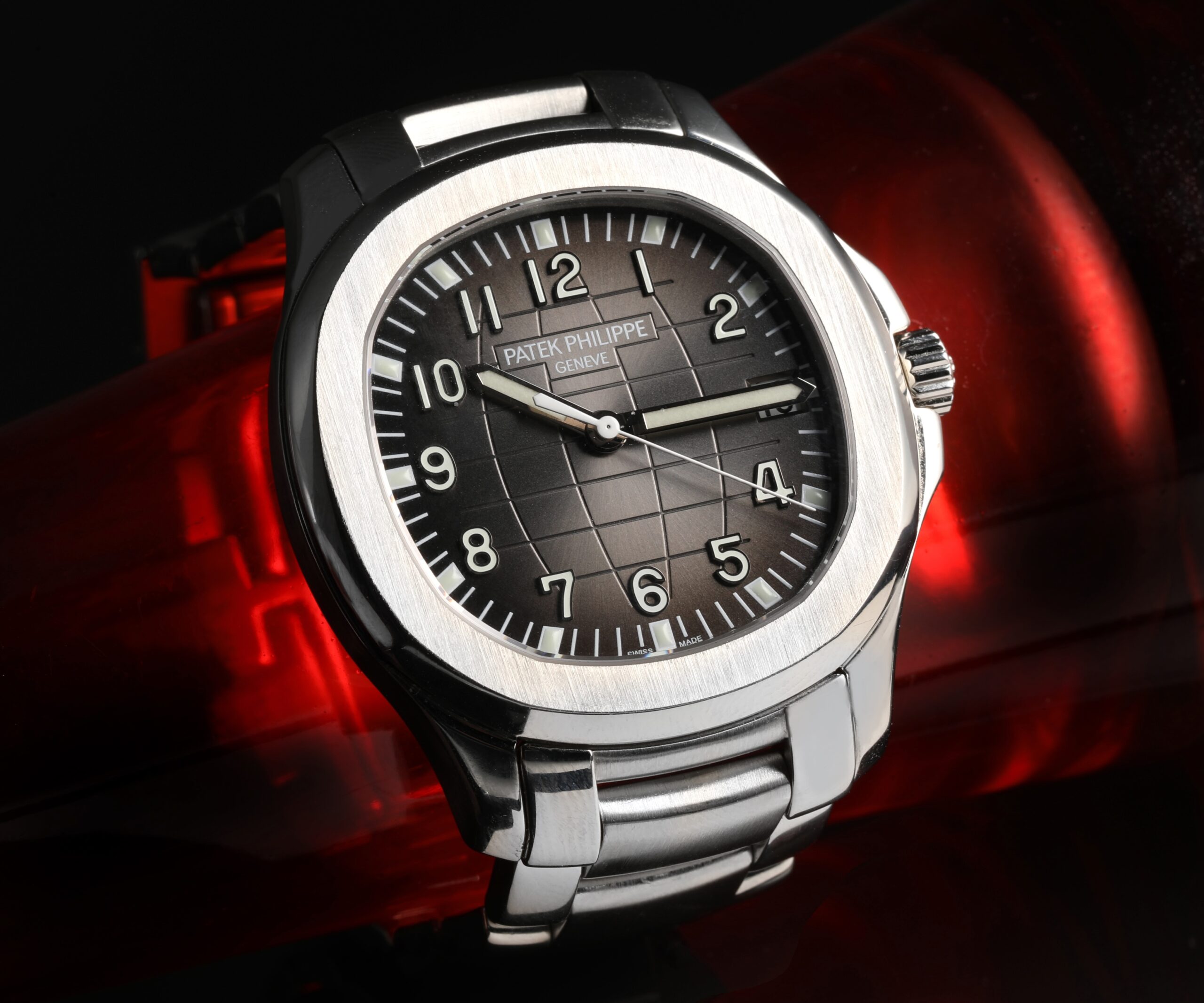 A detailed macro photograph of the Patek Philippe Aquanaut 5167/1A's black embossed dial, showing its grid-like texture and luminous numerals.