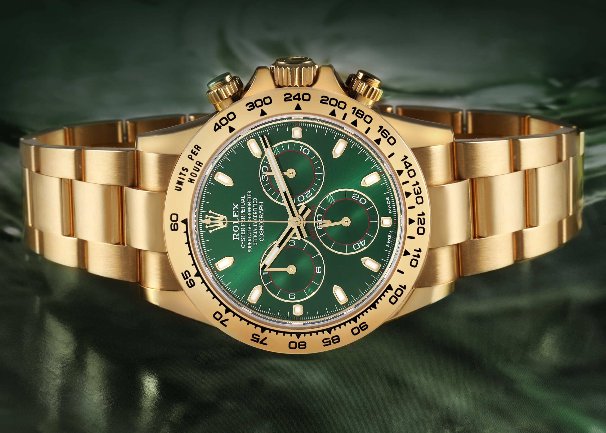 A studio shot of the Rolex Daytona 116508 in yellow gold with a green dial, a bold timepiece famously worn by football legend Lionel Messi.