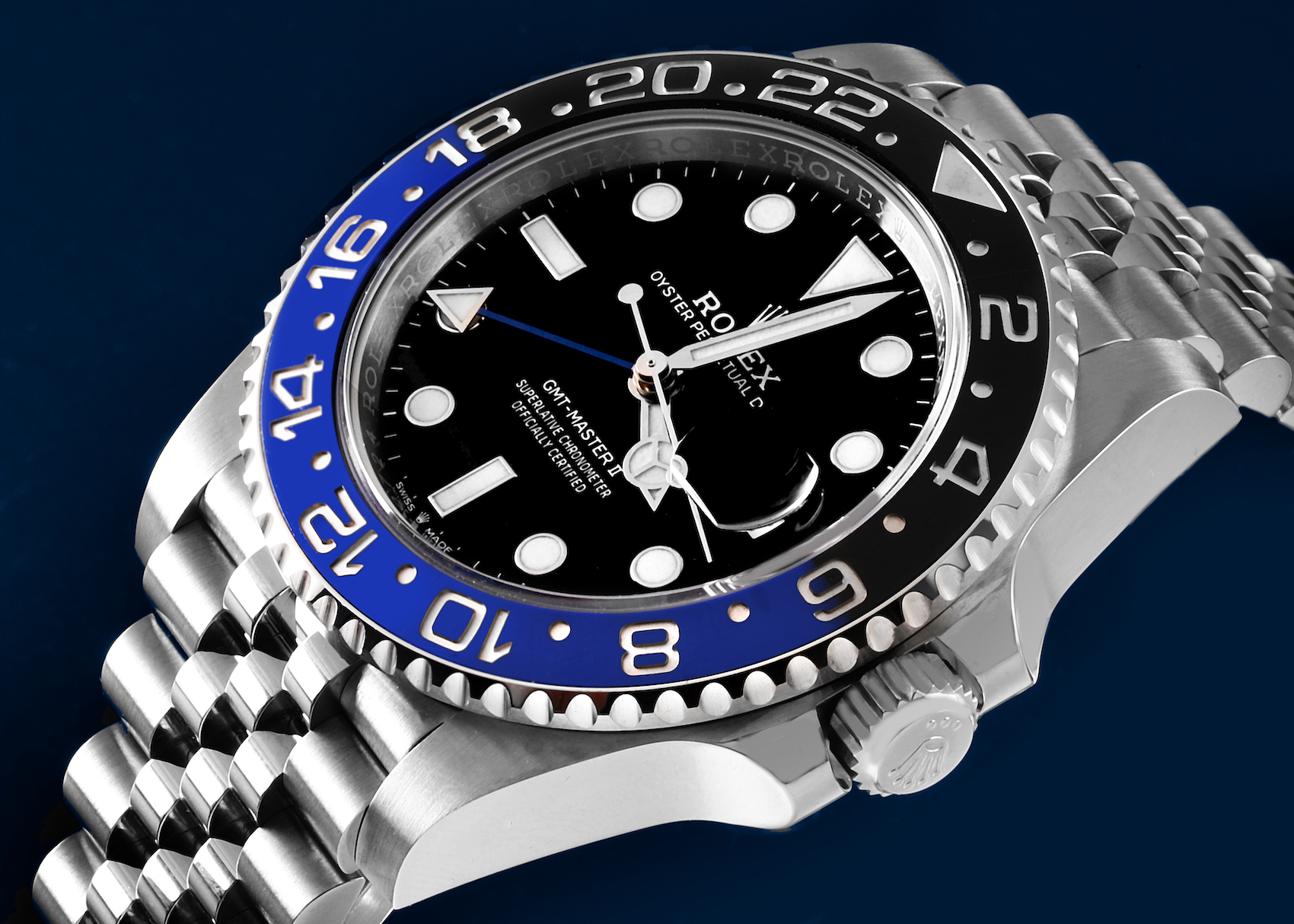 A close-up shot of a Rolex GMT Master II "Batgirl" 126710, showcasing its black dial, blue and black ceramic bezel with 24-hour markers, and stainless steel Jubilee bracelet.