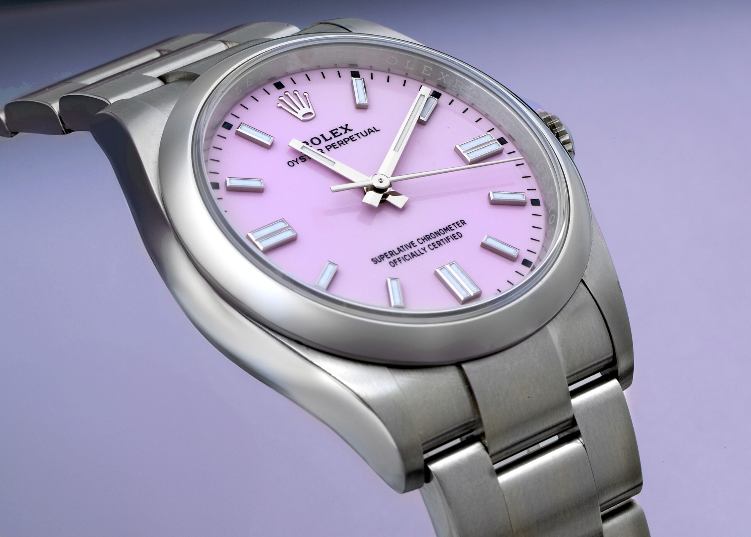An angled view of the stainless steel Rolex Oyster Perpetual (Ref. 126000) with a vibrant candy pink dial, a stylish and modern watch from Lionel Messi's collection.