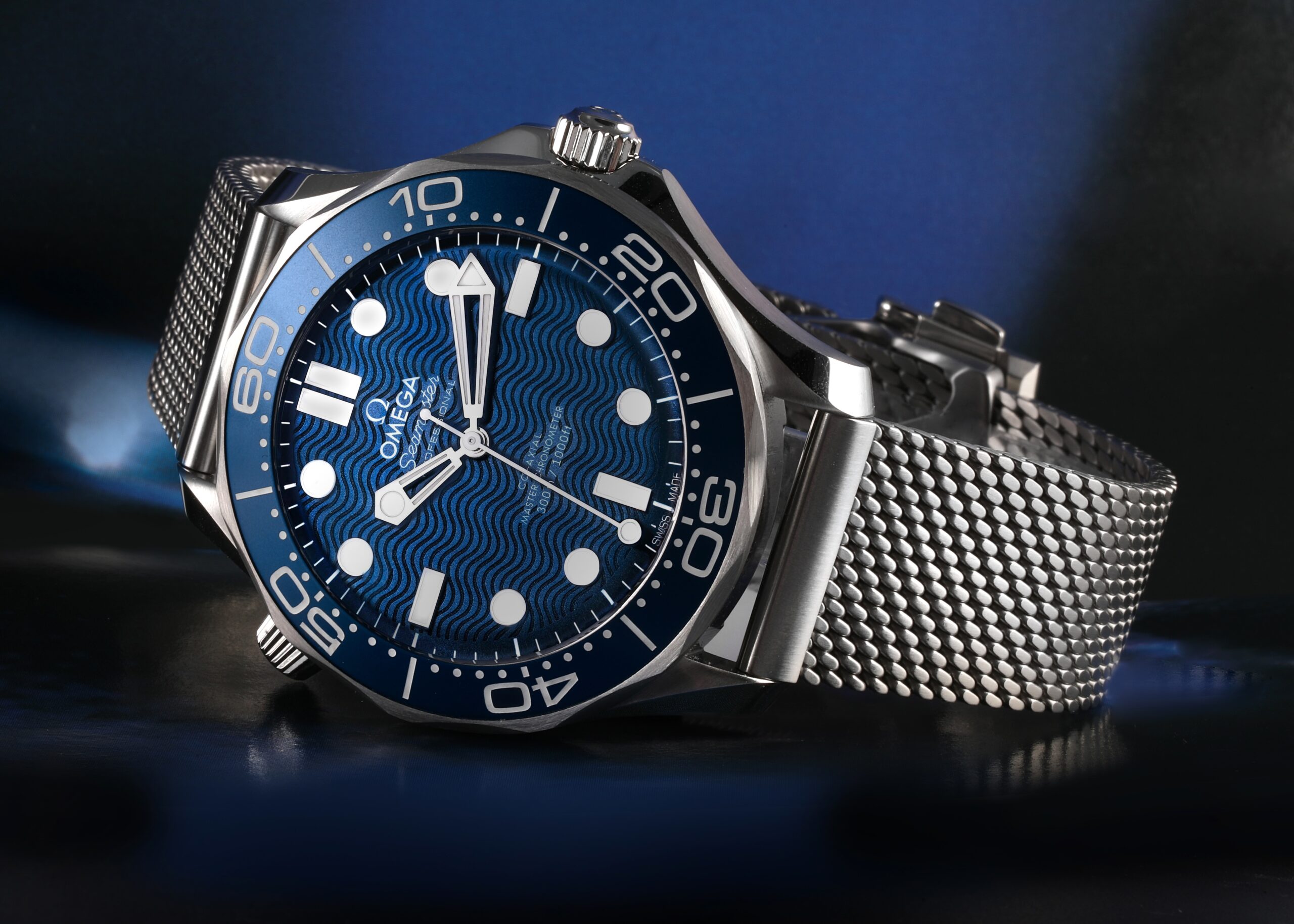 The Omega Seamaster Diver 300M, the watch of James Bond, featuring a blue ceramic wave dial and a stainless steel mesh bracelet.