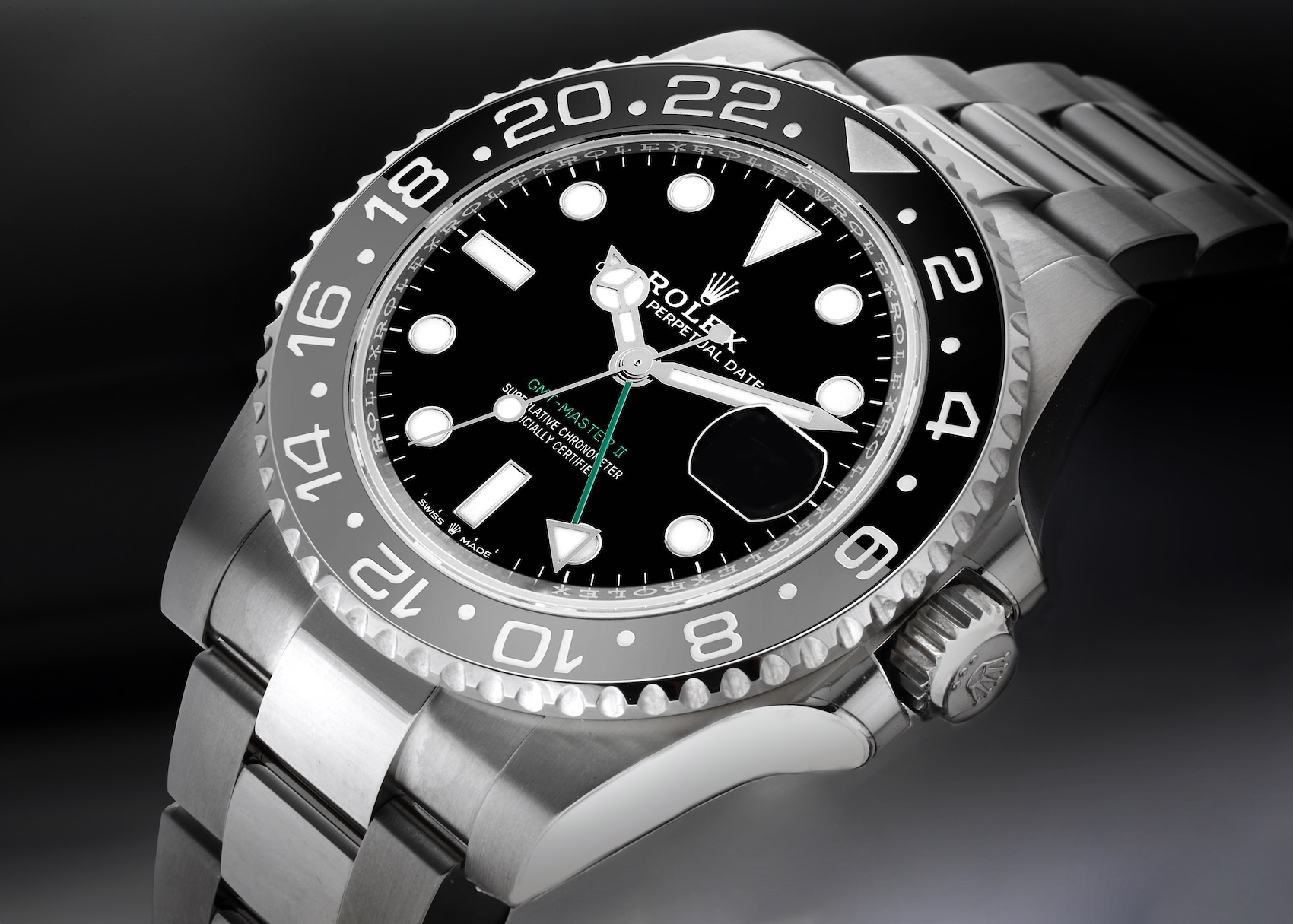 A close-up of the Rolex GMT-Master II 126710, known for its black and grey ceramic bezel. The dial features the luminescent Mercedes hour hand, a staple of Rolex professional models.