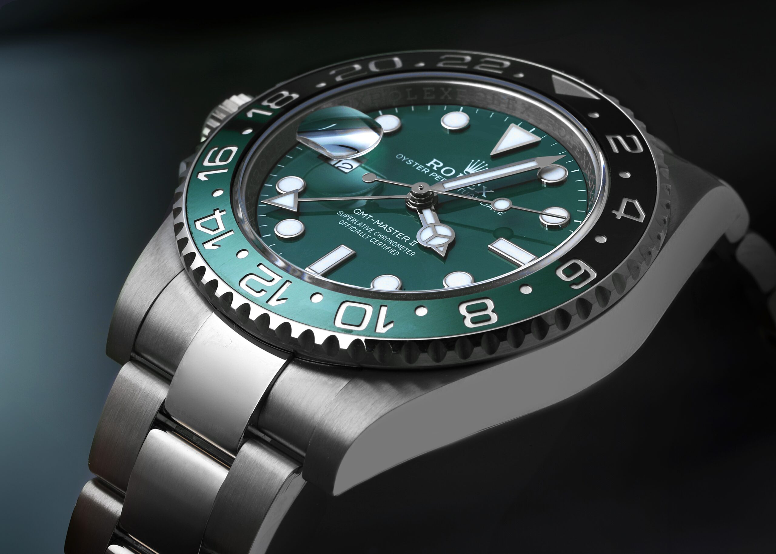A detailed, angled photograph of the white gold Rolex GMT-Master II Sprite, focusing on the gloss of the green dial and the bi-colored green and black ceramic bezel.