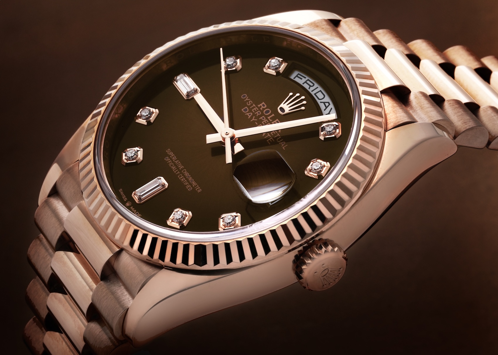 An angled close-up of a Rolex Day-Date 36 (128235) in Everose gold, featuring a rich brown dial set with brilliant and baguette diamond hour markers, a fluted bezel, and the iconic President bracelet.