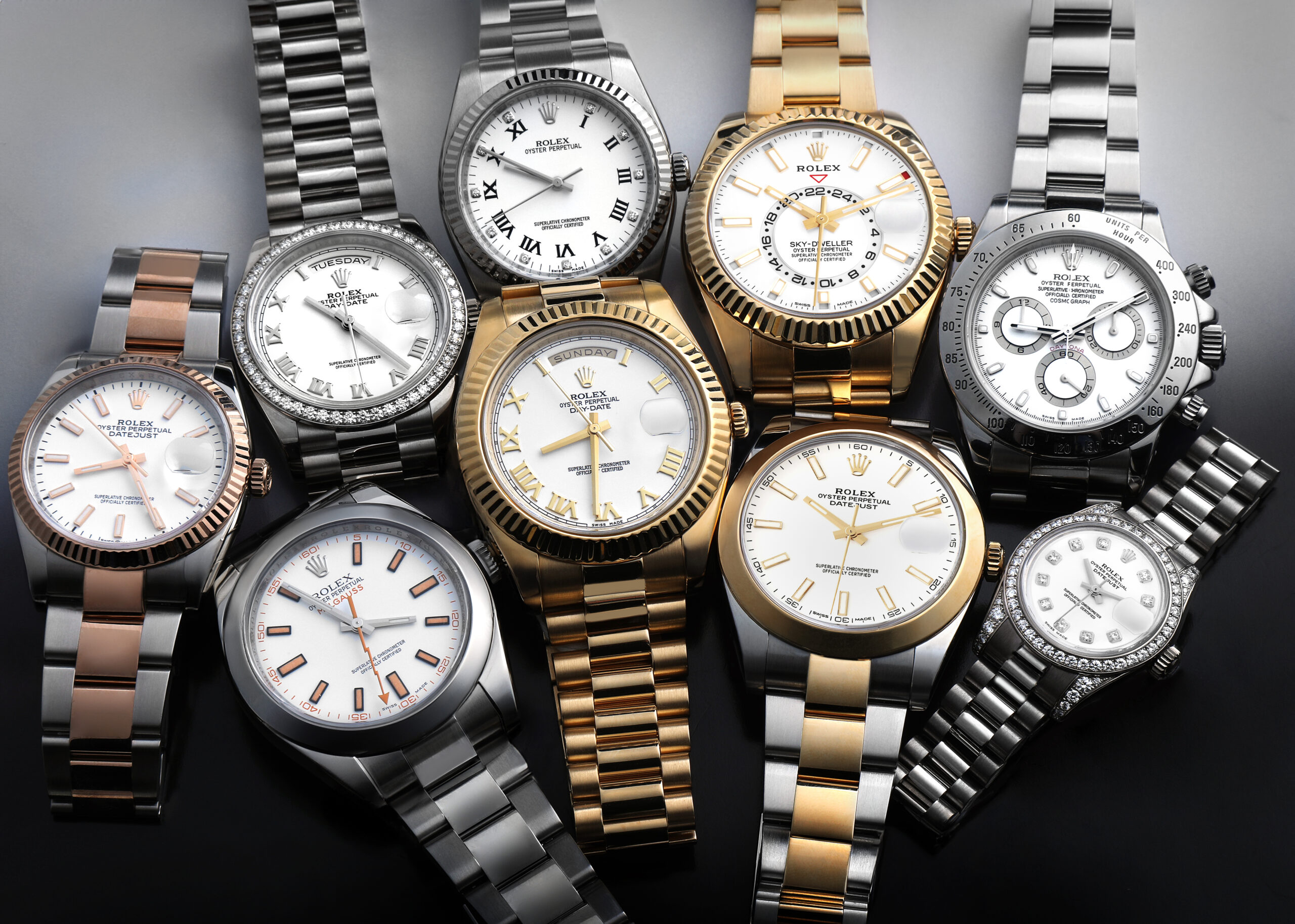 A collection of white dial Rolex watches showing various case sizes, including the Sky-Dweller, Daytona, Datejust 41, and Milgauss.