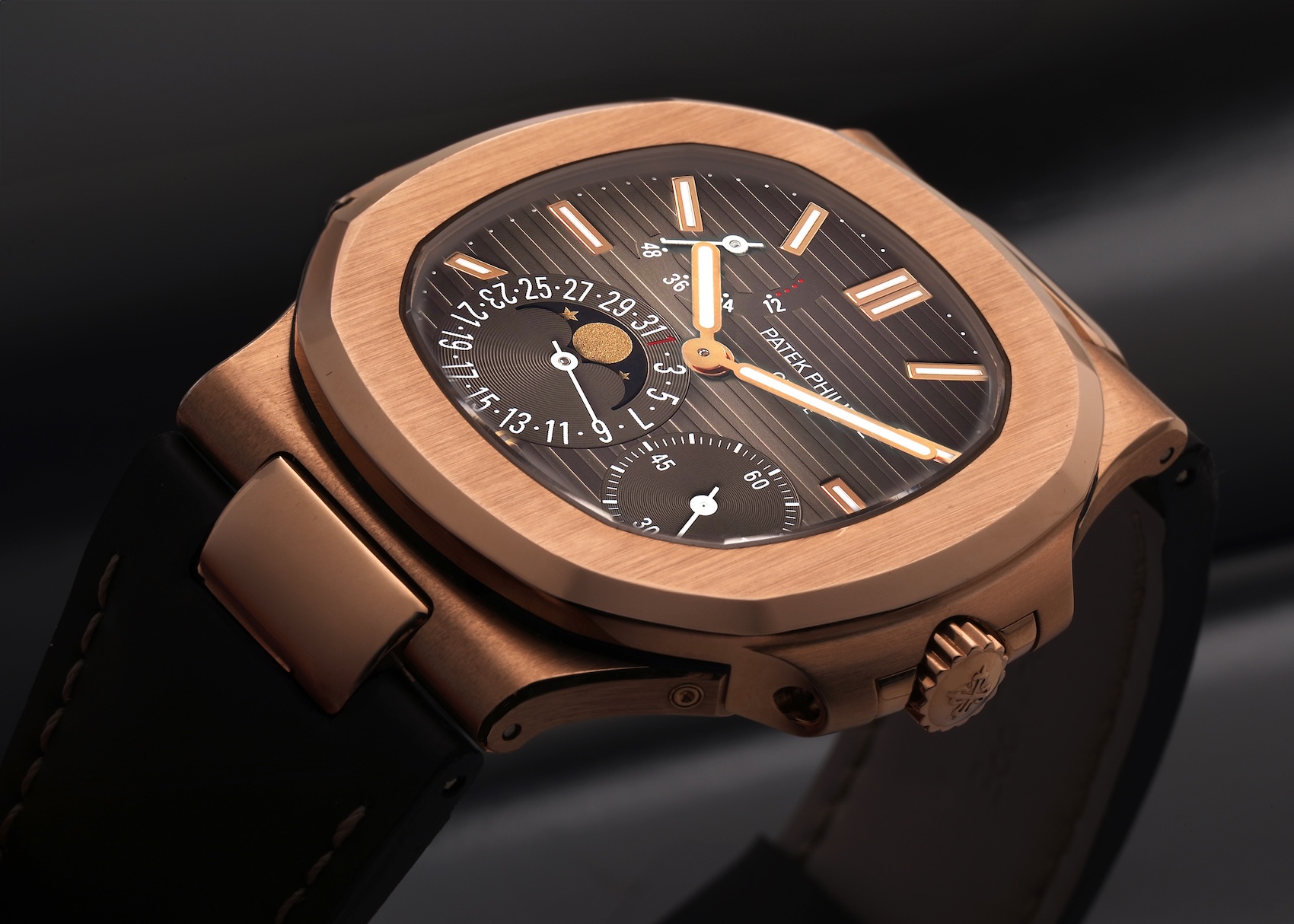 Close-up of the Patek Philippe Nautilus 5712R moonphase dial with power reserve indicator in 18k rose gold.