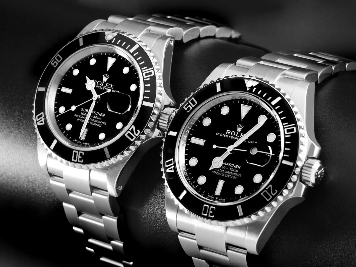 Black and white photo of two stainless steel Rolex Submariner watches, a popular luxury sports watch choice for athletes post-match trophy lift celebrations.