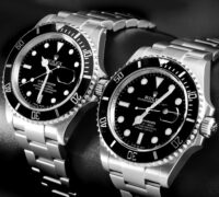 Black and white photo of two stainless steel Rolex Submariner watches, a popular luxury sports watch choice for athletes post-match trophy lift celebrations.