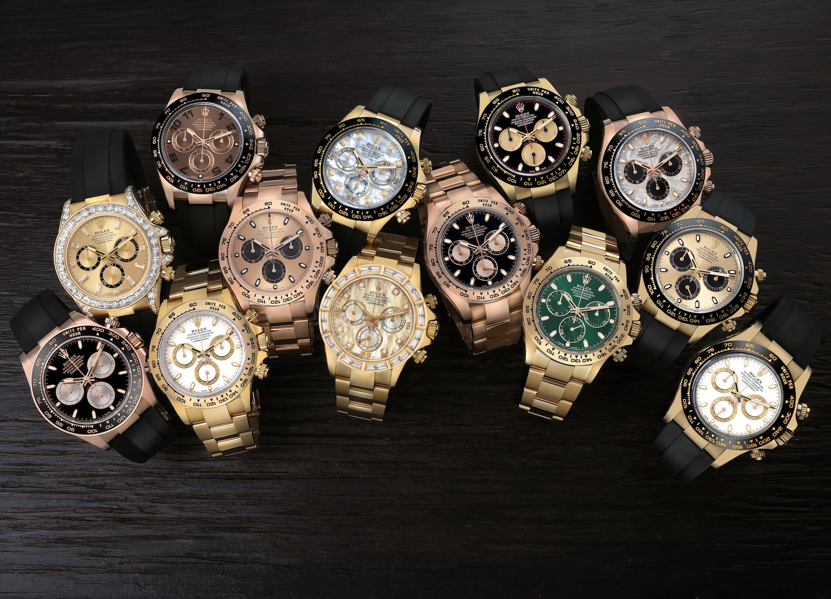 A stunning V-shaped array of authenticated pre-owned Rolex Cosmograph Daytona watches showcasing rare mother-of-pearl, green, and blue dials in stock at Top Quality Designer Watch Shop in Atlanta.