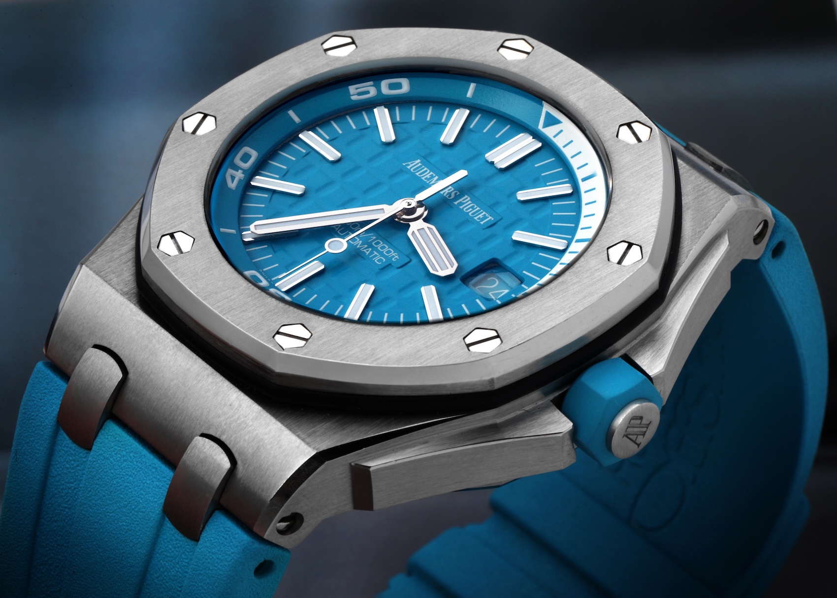 Close-up macro shot of an Audemars Piguet Royal Oak Offshore Diver 15710ST in stainless steel featuring a vibrant turquoise blue Mega Tapisserie dial and matching blue rubber strap.