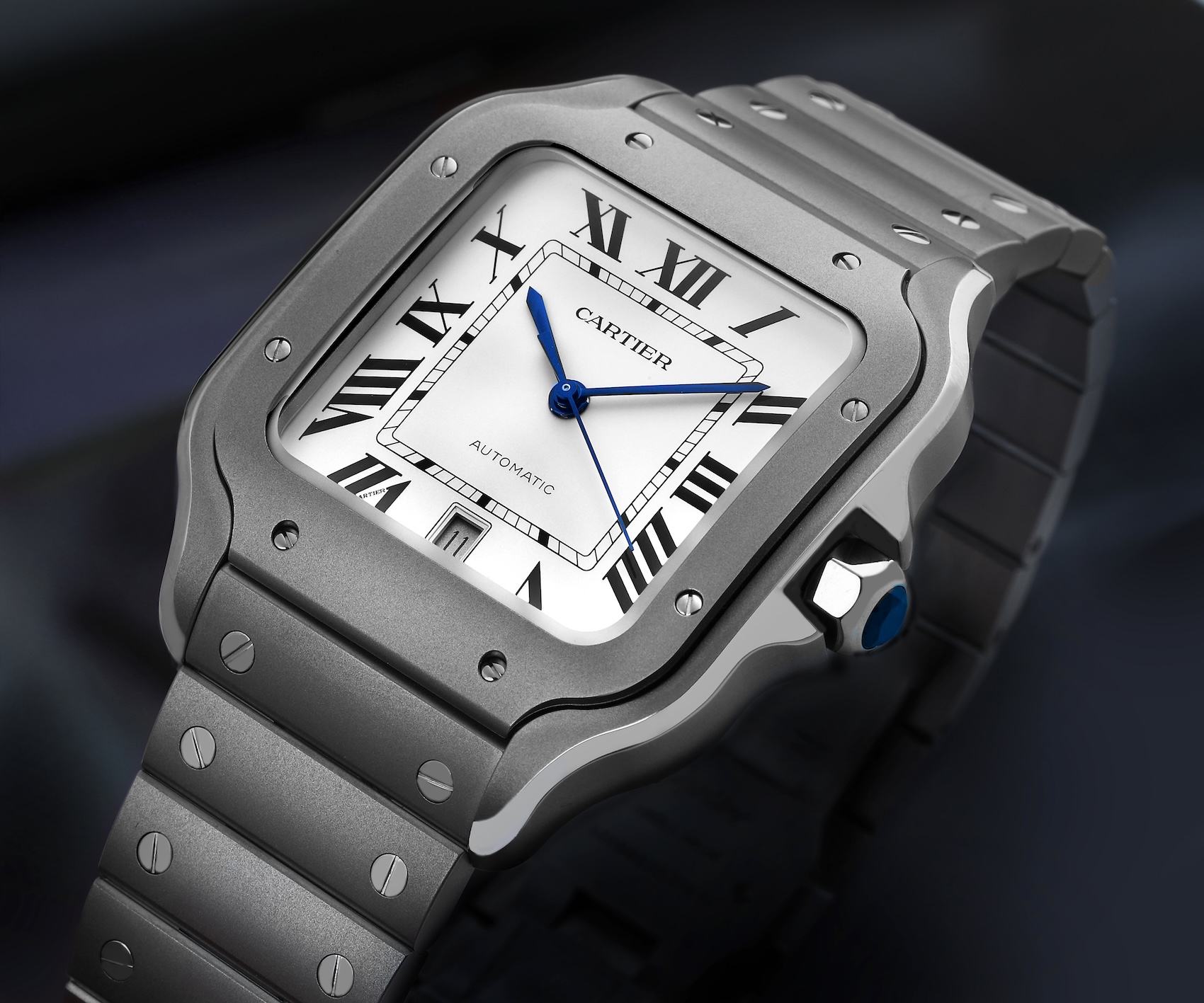 Dramatic angled shot of the Cartier Santos Large Model WSSA0089 in brushed titanium with a silver dial and blued-steel hands.