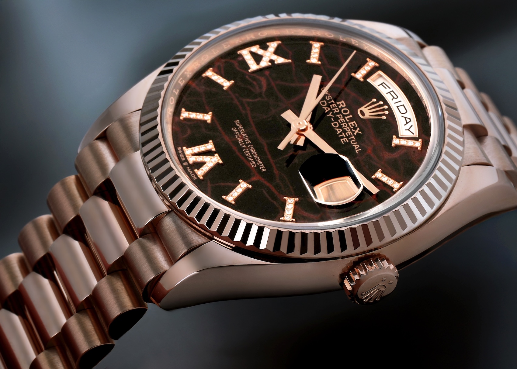 Detailed macro shot of a Rolex Day-Date 36 Ref 128235 in Everose gold featuring a dark brown Eisenkiesel stone dial with diamond-set Roman numerals and a fluted bezel.