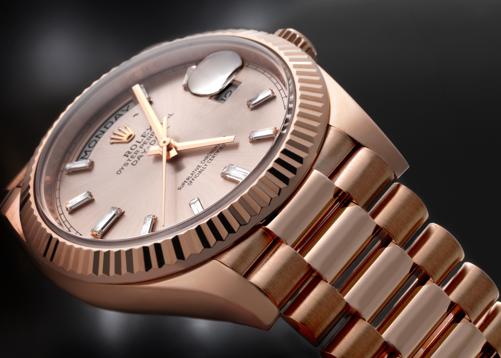 Angled close-up of a Rolex Day-Date 40 Ref 228235 in 18k Everose gold featuring a metallic Sundust dial with ten baguette-cut diamond hour markers and a fluted bezel.