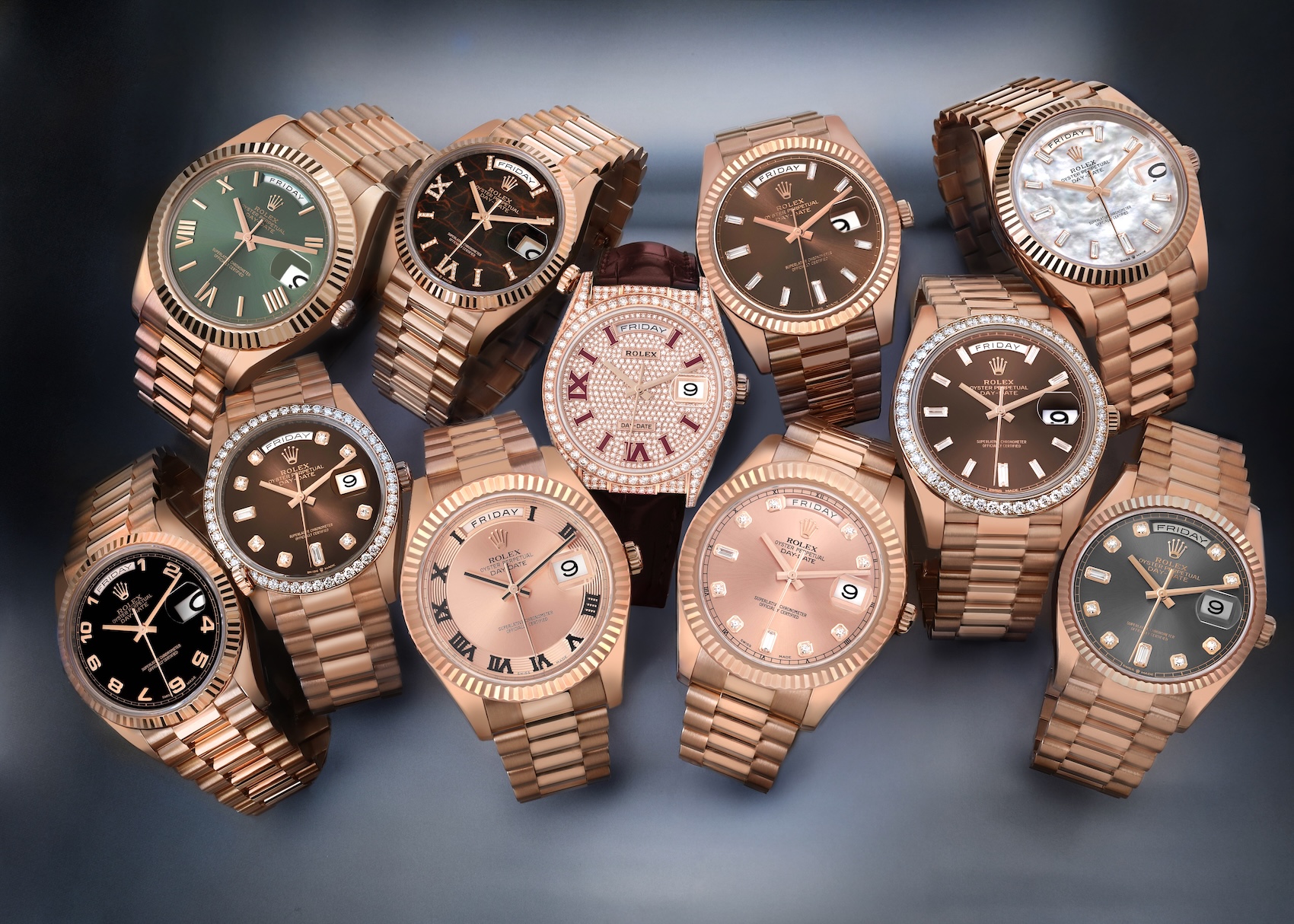 A luxurious collection of nine different Rolex Day-Date watches in 18k Everose gold, displaying a variety of dial configurations including olive green, chocolate, eisenkiesel, and diamond pavé.
