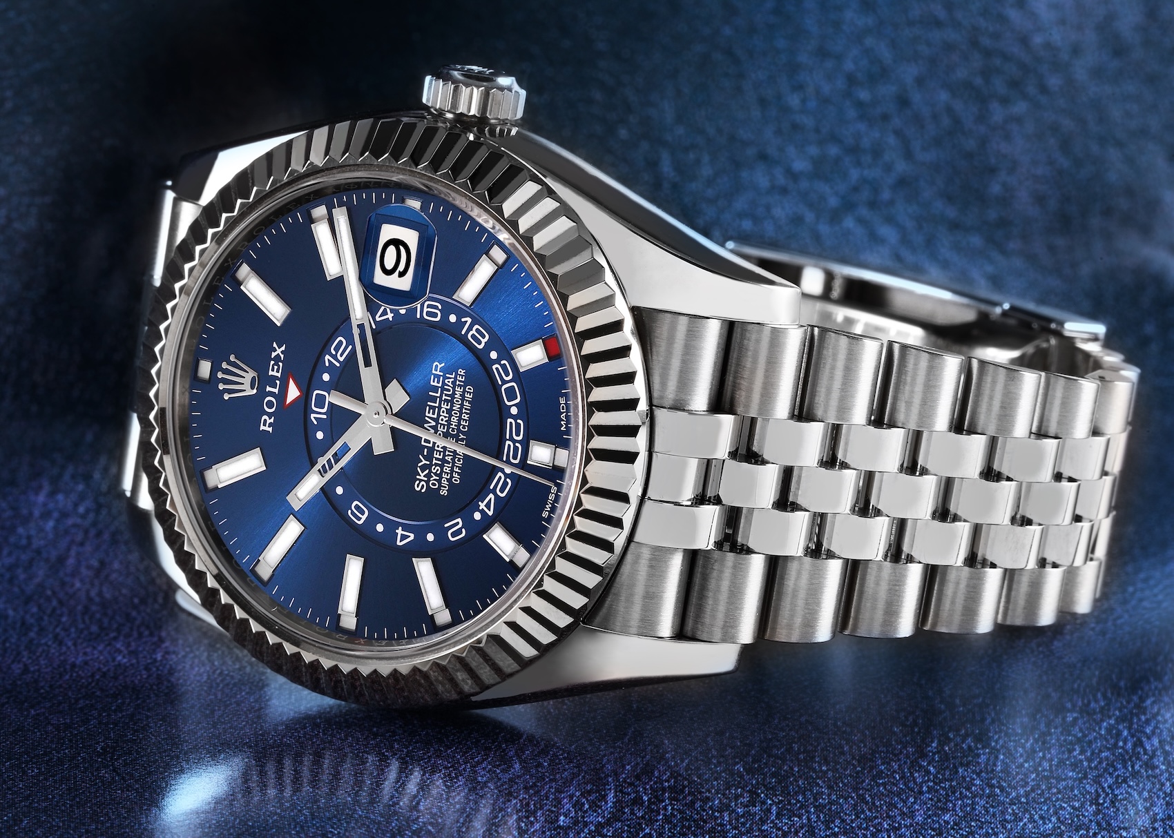 Rolex Sky-Dweller featuring a bright blue dial and fluted white gold bezel on a Jubilee bracelet, reference 336934.