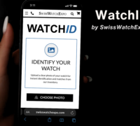 A hand holding a smartphone displaying the WatchID visual search tool on the Top Quality Designer Watch Shop website.